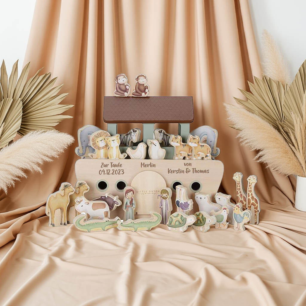 Personalisierte Arche Noah aus Holz mit Tierfiguren, liebevoll arrangiert als Taufgeschenk vor warmem Stoffhintergrund im Schmatzepuffer Stil
