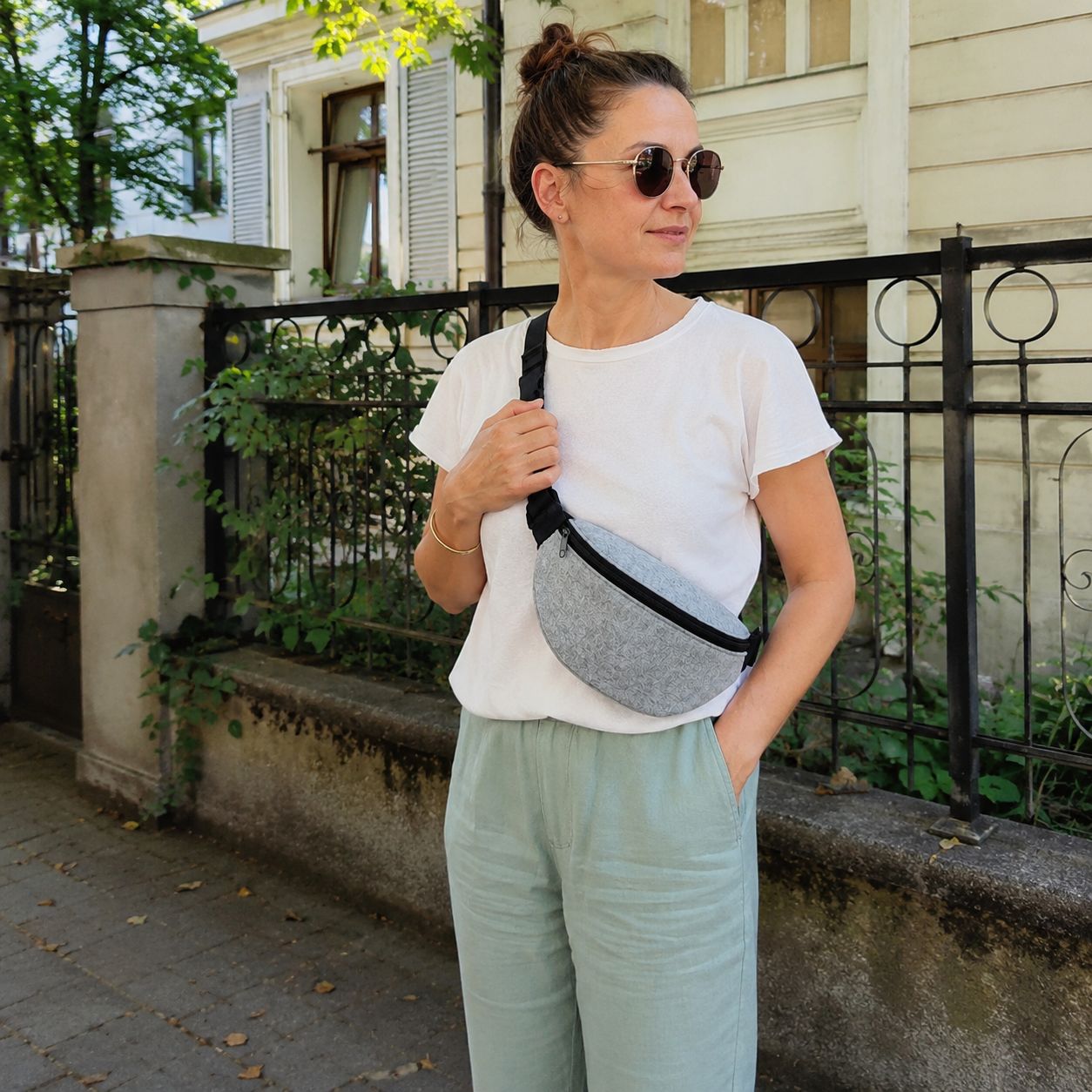 Frau trägt eine hellgraue Filz Bauchtasche beim Spaziergang im Freien – praktische Crossbody-Hüfttasche für Freizeit, Reisen und den täglichen Gebrauch.