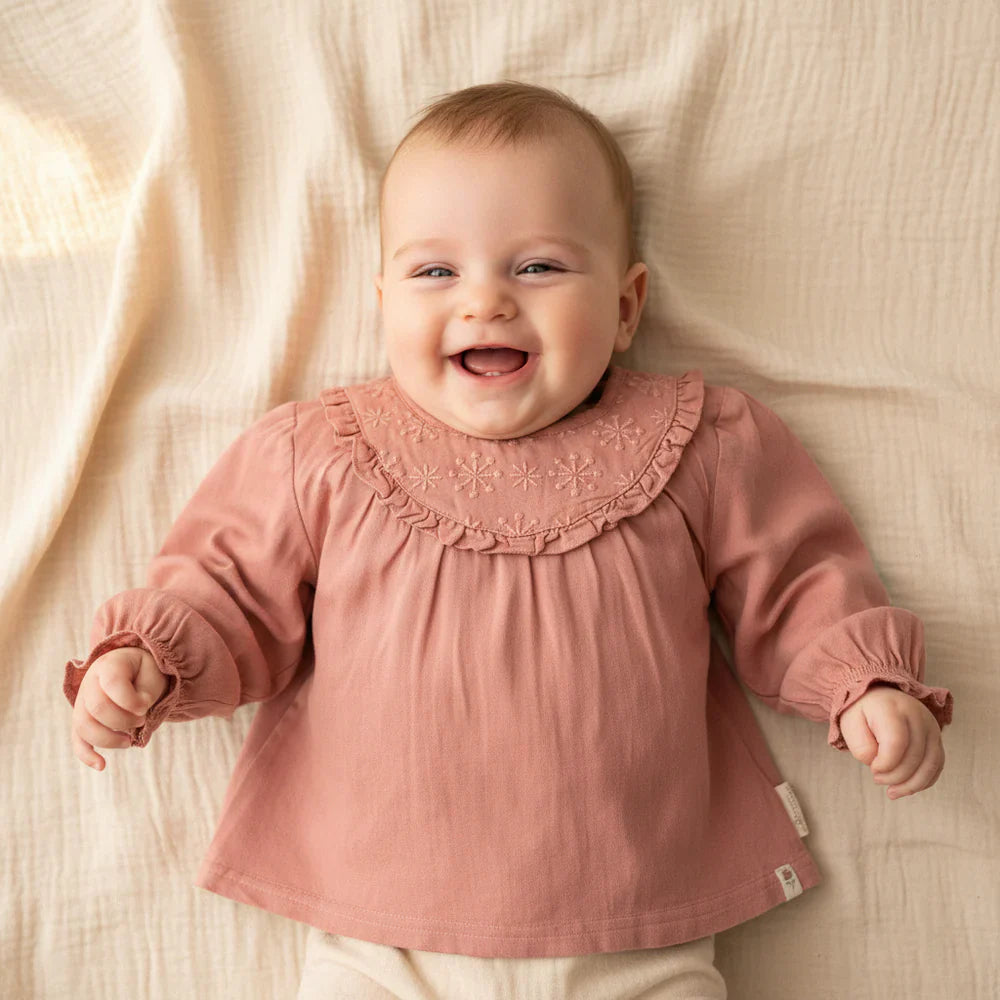 Baby Mädchen trägt rosafarbene langarm Bluse mit Stickerei – weiche Kinderbluse für Alltag und besondere Anlässe