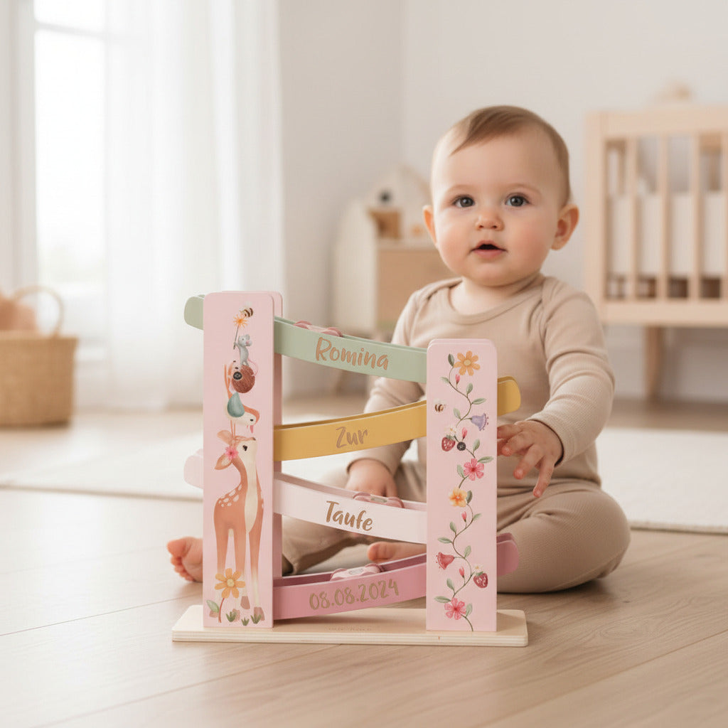 Personalisierte Kugelbahn zur Taufe mit Name und Datum aus Holz als Babygeschenk mit Kind im Hintergrund
